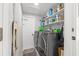 Laundry room with gray front-loading washer and dryer, utility sink, storage shelves and white door at 743 43Rd Ne Ave, St Petersburg, FL 33703