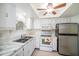 Cozy kitchen featuring white cabinets, tile countertops, and stainless steel appliances at 801 83Rd N Ave # 107, St Petersburg, FL 33702