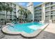 Community pool featuring tropical landscaping, seating area, and lounge chairs at 801 83Rd N Ave # 107, St Petersburg, FL 33702