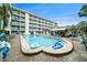 Community pool and spa area surrounded by lounge chairs and lush landscaping at 801 83Rd N Ave # 107, St Petersburg, FL 33702