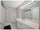 Unique bathroom with colorful wallpaper, vanity sink and a wall-to-wall mirror at 8980 Antigua Dr, Seminole, FL 33777