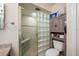 Well-maintained bathroom with glass block shower, neutral tile, and wooden storage cabinet at 8980 Antigua Dr, Seminole, FL 33777