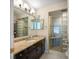 Bathroom with a marble counter top, glass brick shower, and a wall mirror at 8980 Antigua Dr, Seminole, FL 33777