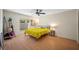 Cozy bedroom with wood floors, ceiling fan, and a large window providing natural light at 8980 Antigua Dr, Seminole, FL 33777
