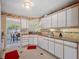 Functional kitchen with white cabinetry, granite countertops, and tile backsplash at 8980 Antigua Dr, Seminole, FL 33777