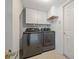 Laundry room with modern washer and dryer, storage cabinets, and a convenient door, perfect for efficient chores at 8980 Antigua Dr, Seminole, FL 33777