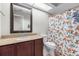 Bathroom with granite countertop, vanity, toilet, and shower with patterned curtains at 9047 Quail Creek Dr, Tampa, FL 33647