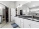 Bright bathroom featuring double sinks, modern gray tiling, and two large storage closets at 9047 Quail Creek Dr, Tampa, FL 33647