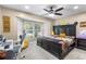 Charming bedroom with a large bay window, a ceiling fan and an inviting, dark wood bed frame at 9047 Quail Creek Dr, Tampa, FL 33647