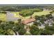 Aerial view of community clubhouse next to golf course surrounded by lush trees and well maintained landscape at 9047 Quail Creek Dr, Tampa, FL 33647