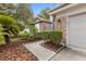 View of home's front entrance with lush landscaping and brick accents on a sunny day at 9047 Quail Creek Dr, Tampa, FL 33647