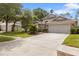 Charming single Gathering home with a lush front lawn and mature trees on a sunny day at 9047 Quail Creek Dr, Tampa, FL 33647