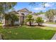 Charming single Gathering home with a lush front lawn and mature trees on a sunny day at 9047 Quail Creek Dr, Tampa, FL 33647