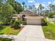 Charming single Gathering home with a lush lawn, mature trees and a two car garage at sunset at 9047 Quail Creek Dr, Tampa, FL 33647