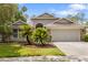 Charming single Gathering home with a lush front lawn and a two car garage on a sunny day at 9047 Quail Creek Dr, Tampa, FL 33647
