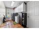 Well-organized laundry room with modern washer/dryer, storage cabinets, sink, and hardwood floors at 9047 Quail Creek Dr, Tampa, FL 33647