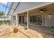 Covered patio area with ceiling fans, sliding doors to the house and surrounding scenery at 9047 Quail Creek Dr, Tampa, FL 33647