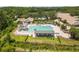 Aerial view of community pool with slide, covered seating, and well-maintained landscaping and proximity to tennis courts at 9047 Quail Creek Dr, Tampa, FL 33647