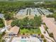 Aerial view of multiple tennis courts, clubhouse, putting green, and lounging by pool, showcasing the community's amenities at 9047 Quail Creek Dr, Tampa, FL 33647