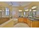 Luxurious bathroom featuring granite counters, a jacuzzi tub, and decorative chandelier lighting at 920 Symphony Isles Blvd, Apollo Beach, FL 33572