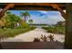Picturesque view of a sandy beach with waterfront homes, captured from a shaded gazebo at 920 Symphony Isles Blvd, Apollo Beach, FL 33572