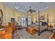Serene main bedroom with a tray ceiling, hardwood floors and decorative area rug at 920 Symphony Isles Blvd, Apollo Beach, FL 33572