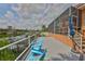 Outdoor seating on a deck next to the water with a blue umbrella near the outdoor steps at 920 Symphony Isles Blvd, Apollo Beach, FL 33572