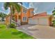 Impressive two-story Mediterranean home featuring a tile roof, two-car garage, and lush landscaping at 920 Symphony Isles Blvd, Apollo Beach, FL 33572