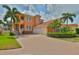 Charming Mediterranean-style home boasting a paver driveway, two-car garage, and vibrant landscaping at 920 Symphony Isles Blvd, Apollo Beach, FL 33572