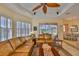 Cozy living room leading to outdoor pool area, with ceiling fan and comfortable seating at 920 Symphony Isles Blvd, Apollo Beach, FL 33572