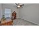 Well-lit bedroom with desk, bookshelf, and a comfortable chair, great for a study space at 9423 Lemon Drop Loop, Sun City Center, FL 33573