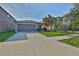 Well-maintained single-story home with a two-car garage and green lawn at 9423 Lemon Drop Loop, Sun City Center, FL 33573