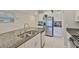 Granite kitchen island with double sinks, stainless refrigerator, and stove at 9423 Lemon Drop Loop, Sun City Center, FL 33573