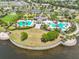 Aerial view of the community pool with palm trees, lounge chairs and manicured grounds at 9423 Lemon Drop Loop, Sun City Center, FL 33573