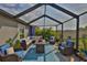 Inviting screened-in porch with wicker seating and blue accents at 9423 Lemon Drop Loop, Sun City Center, FL 33573