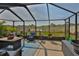 Screened-in porch featuring wicker furniture and a pond view at 9423 Lemon Drop Loop, Sun City Center, FL 33573