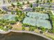 Aerial view of the community tennis and basketball courts near a lake at 9423 Lemon Drop Loop, Sun City Center, FL 33573