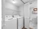 Laundry area with modern washer and dryer, plus extra storage and access to another full bathroom at 9450 Harbor Greens Way # 207, Seminole, FL 33776