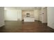 Open-concept living room featuring wood floors and a view of the adjacent modern kitchen at 9512 Summers Cay Cir, Thonotosassa, FL 33592