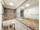 This bathroom features a large vanity, wood-look tile flooring, and a tub with gray tile surround at 1025 Reading Rd, Lutz, FL 33558