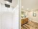 This bathroom features a double sink vanity, wood-look tile flooring, and a walk-in shower at 1025 Reading Rd, Lutz, FL 33558