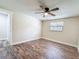 Bright bedroom features modern ceiling fan, wood-look floors, and natural light from the window at 1025 Reading Rd, Lutz, FL 33558