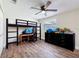 Bedroom with ceiling fan, wood-look floors, large dresser, computer desk, and bunk bed at 1025 Reading Rd, Lutz, FL 33558
