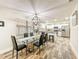 Open dining area with a glass table and kitchen view featuring white cabinets and stainless steel appliances at 1025 Reading Rd, Lutz, FL 33558