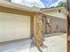 Exterior side view features garage, secondary entrance, stone design, and lush landscaping at 1025 Reading Rd, Lutz, FL 33558