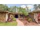Inviting front entrance with stone accents, a brick path, lush landscaping, and comfortable seating on the porch at 1025 Reading Rd, Lutz, FL 33558