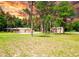 Sprawling property with mature trees, a well-manicured lawn, and a charming home featuring an attached garage at 1025 Reading Rd, Lutz, FL 33558