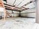 Spacious metal constructed garage with a concrete floor and wooden stairs at 1025 Reading Rd, Lutz, FL 33558