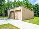 Exterior of large, metal constructed two-car garage with a concrete driveway at 1025 Reading Rd, Lutz, FL 33558