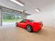Clean, epoxy floored garage with view of the property and a red sports car at 1025 Reading Rd, Lutz, FL 33558